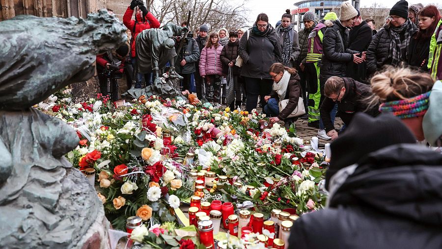 Varias personas depositan flores y encienden velas tras el atentado con vehículo contra el mercado navideño de Magdeburgo