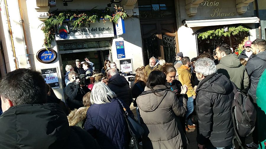 Multitud celebra en Logroño la venta del Gordo de Navidad 2024 en la administración nº6.  Decoración navideña, cartel con el número 72480 y presencia de prensa.