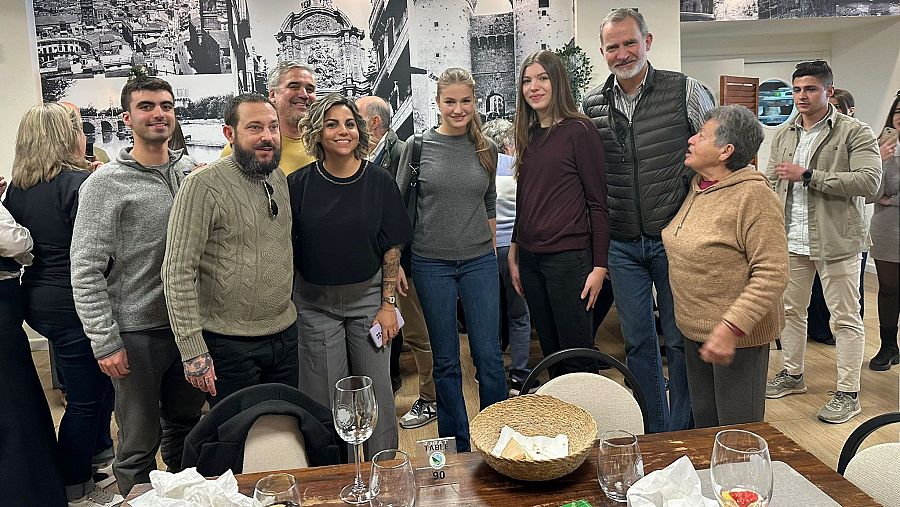 El rey Felipe, junto a sus hijas, la princesa Leonor y la infanta Sofía, posan junto algunos vecinos, en el restaurante Albufera, en El Palmar