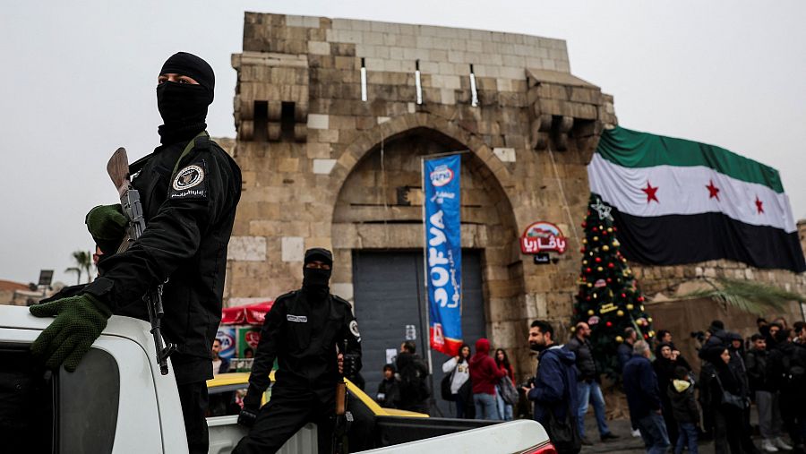 Miembro del Gobierno de Salvación Sirio con un fusil en la protesta contra la quema del árbol de Navidad en Hama, Siria