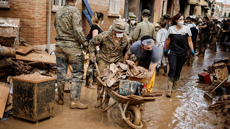 Militares y voluntarios colaboran en la limpieza, retirando lodo y ayudando a los afectados por la dana en Paiporta, Valencia.