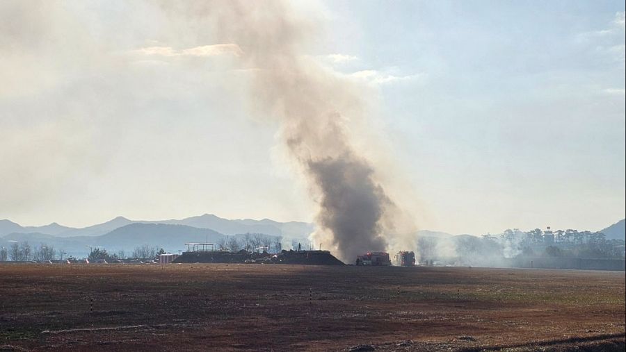 Los bomberos trabajan para extinguir el incendio en la pista de aterrizaje del aeropuerto internacional de Muan