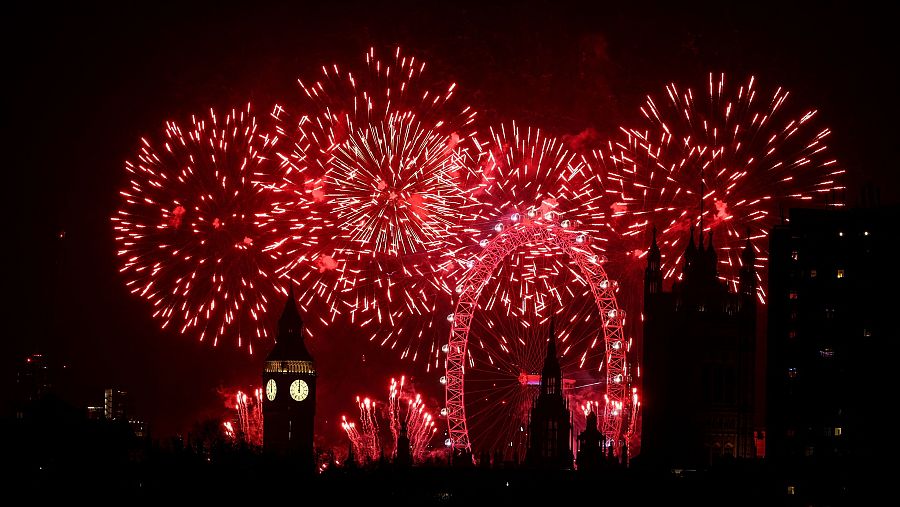 El Palacio de Westminster iluminado con fuegos artificiales rojos en Nochevieja