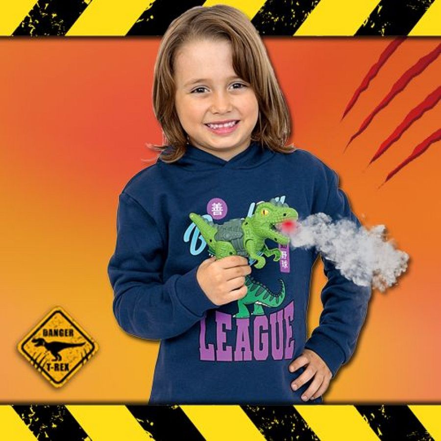 Niño sonriente con sudadera azul y capucha, sostiene un dinosaurio de juguete verde con luz roja. Fondo naranja con marcas de garras y cinta de precaución.