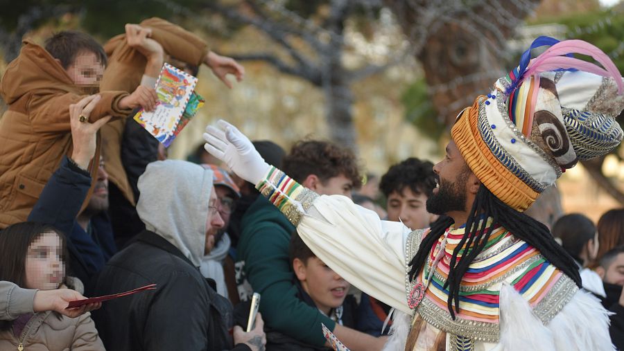 Un niño entrega su carta a un paje en la cabalgata de Barcelona