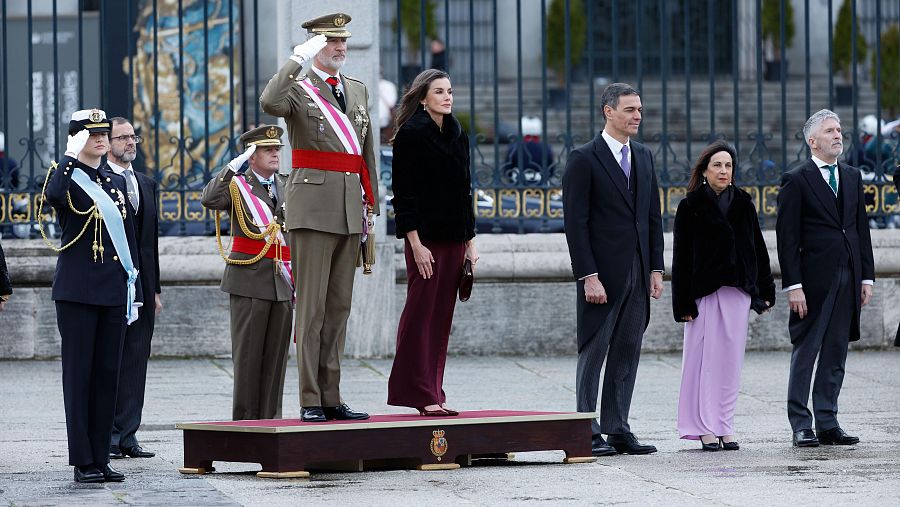 Pascua Militar 2025: El Rey Felipe VI, con uniforme, saluda junto a la Reina Letizia y el Presidente del Gobierno Pedro Sánchez, entre otros asistentes.