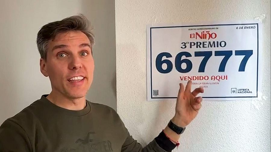 Un hombre señala un cartel de lotería que anuncia un tercer premio del sorteo de El Niño, con el número 66777, vendido en ese mismo establecimiento el 6 de enero.