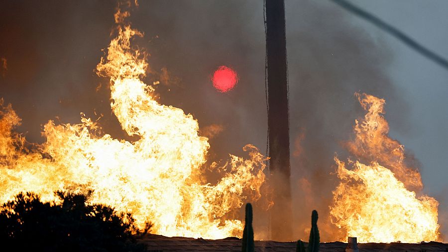 El sol se ve a través de las llamas y el humo en Altadena, California