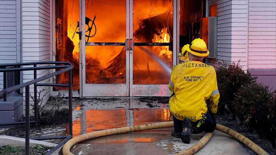 Un bombero trabaja en la extinción de un incendio en Lake Avenue