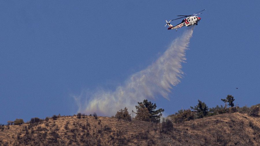 Un helicóptero arroja agua sobre el incendio Eaton en el Bosque Nacional de Los Ángeles