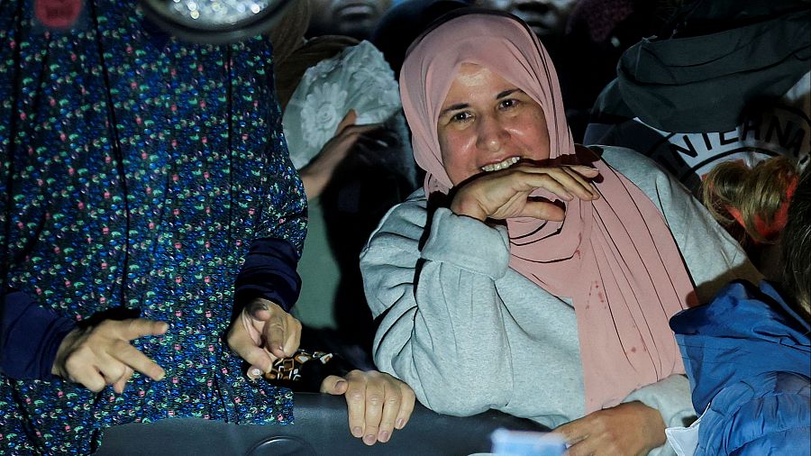 Una prisionera palestina liberada sonríe desde el interior de un autobús