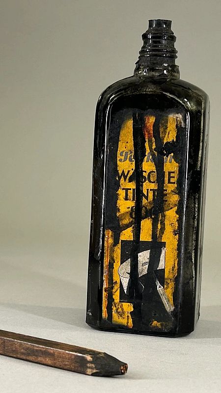 Botella de tinta negra con etiqueta desgastada (