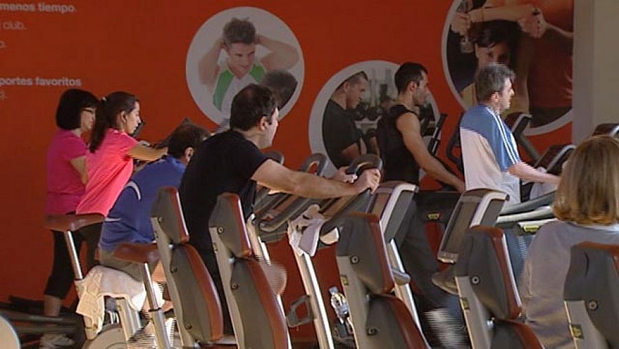 Varias personas caminando en cintas de correr de un gimnasio