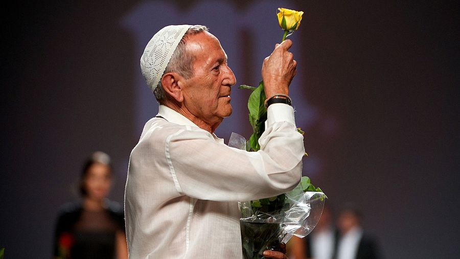 El diseñador Elio Berhanyer posa con una rosa amarilla tras su desfile en la pasarela de Madrid