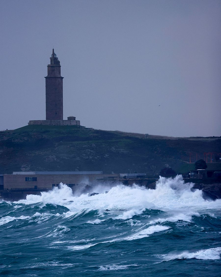 Las olas rompían este martes contra la costa de la ciudad de A Coruña, con la Torre de Hércules al fondo