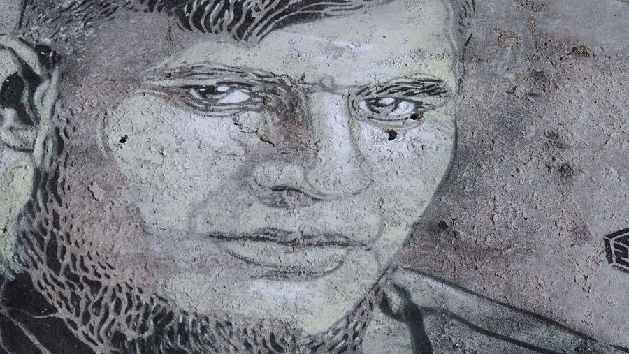 Retrato en blanco y negro estilo grafiti de un soldado con barba y pelo corto, expresión seria.  Arte urbano que refleja la resiliencia.