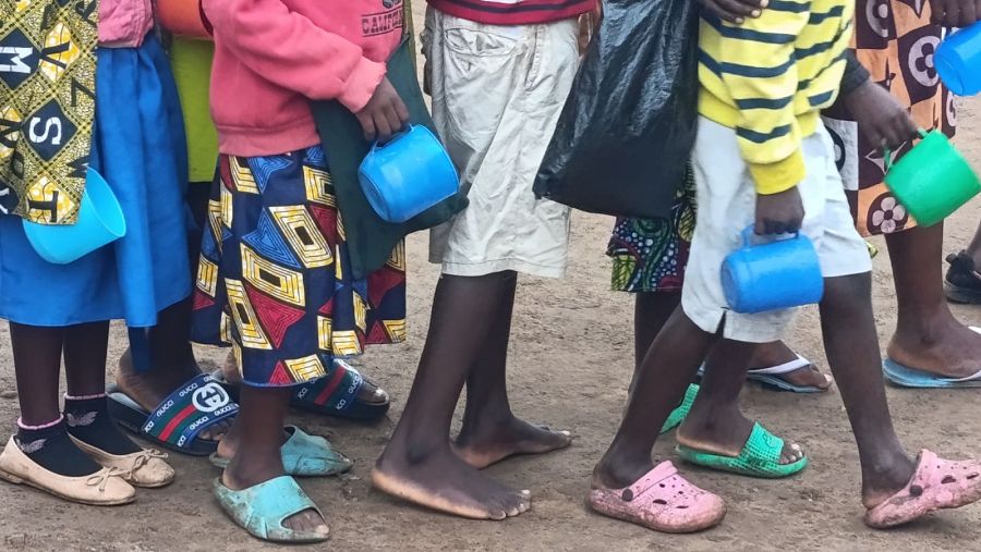 Niños esperan el reparto de comida en el colegio de Mbayani en la ciudad de Blantyre