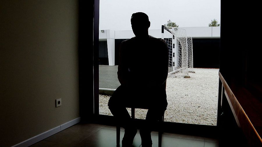 Silueta de persona sentada mirando a través de una puerta acristalada hacia un patio con una portería.  Texto: más de 8 años y 3 meses sin beber.