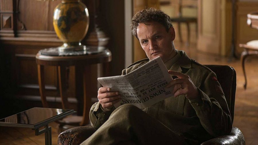 Hombre en uniforme militar leyendo un periódico, 