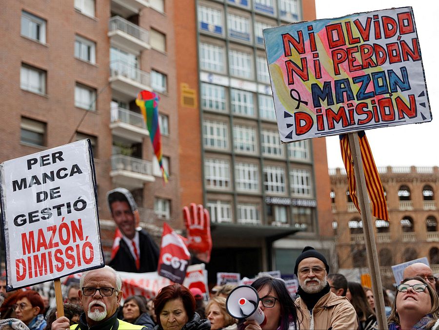 Protesta en Valencia con pancartas pidiendo la dimisión de Mazón por la gestión de la DANA.  Se ven banderas arcoíris y la senyera entre los manifestantes.