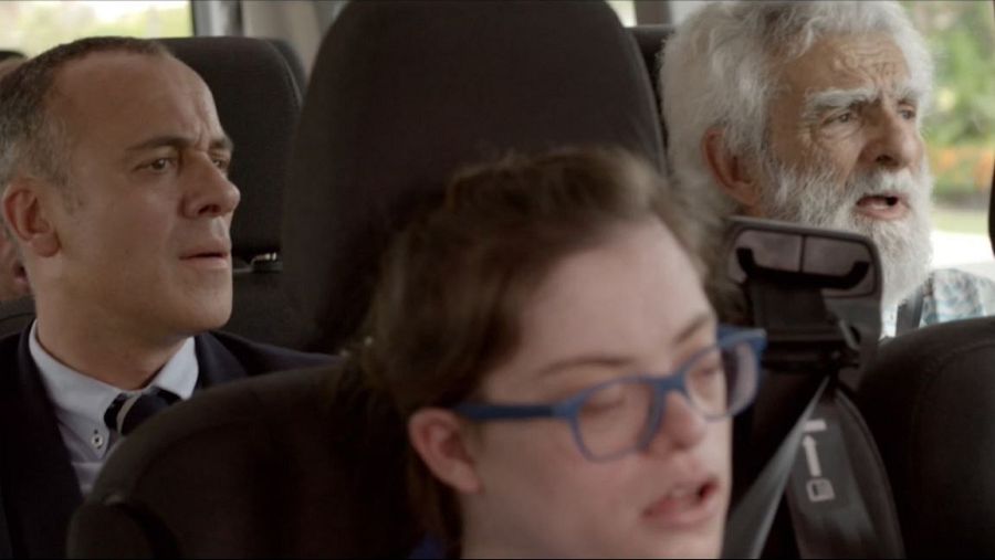 Tres personas en un vehículo, una de ellas Javier Gutiérrez con traje, muestran diversas expresiones faciales.  Todos llevan puestos los cinturones de seguridad.