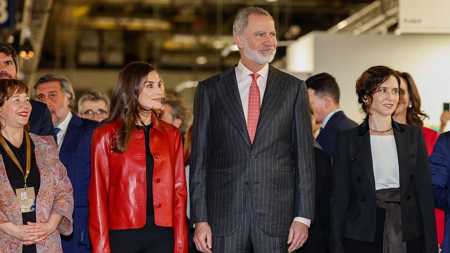 Reyes de España e Isabel Díaz Ayuso asisten a la inauguración de ARCO 2025. La reina luce chaqueta roja, el rey traje gris y Ayuso chaqueta negra.