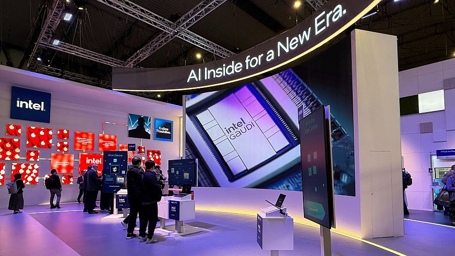 Stand de Intel en evento tecnológico, promocionando la IA y el procesador Gaudí. Cartel: 