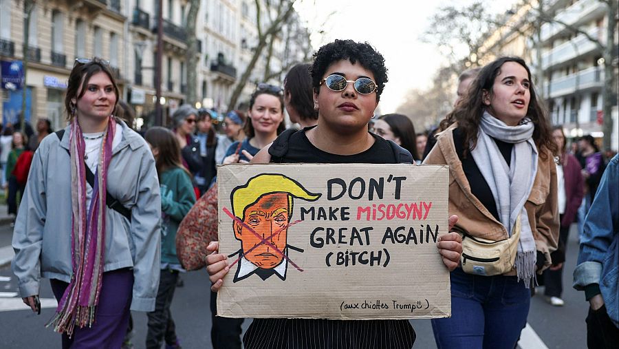 Una mujer lleva una pancarta en la que critica a Donald Trump en una de las manifestaciones en París.