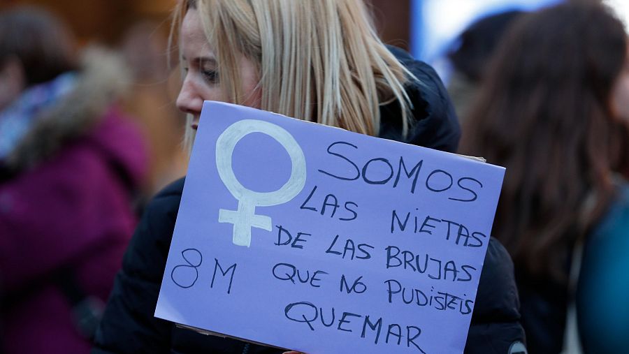 Una mujer lleva una pancarta que dice: 