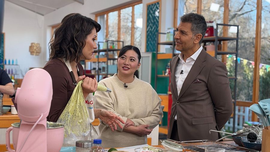 Escena de 'Bake Off: famosos al horno' con Nagore Robles, Noelia Tomoshige y Paco Roncero.  Nagore explica algo, Noelia escucha y Paco observa.
