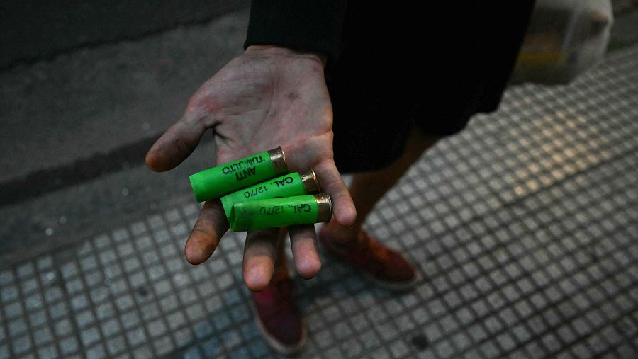 Un hombre muestra cartuchos vacíos durante la protesta de jubilados