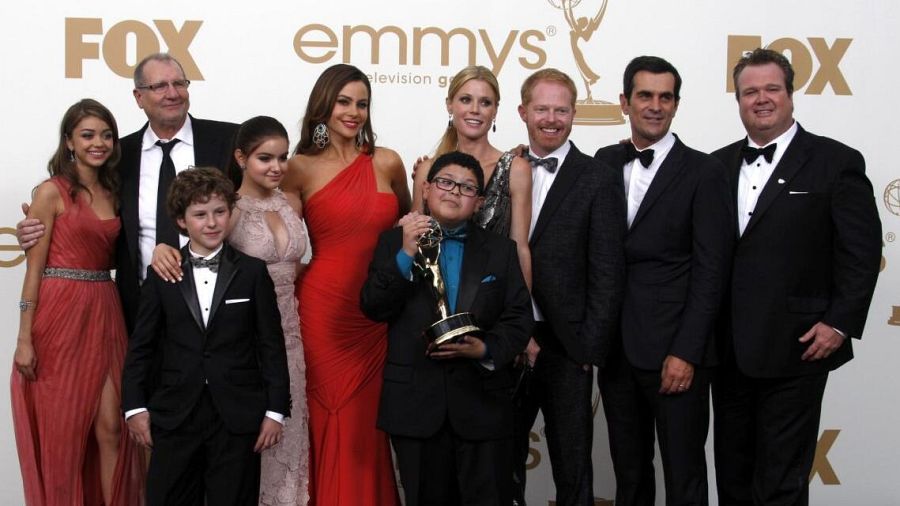 Reparto de 'Modern Family' en los Emmy. Rico Rodriguez sostiene un premio, todos visten atuendos formales. Ambiente festivo.