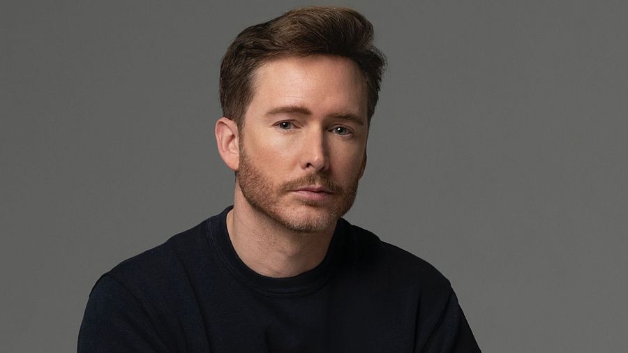 Retrato de Pablo Rivero durante la promoción de su libro.  Expresión seria, pelo corto y barba. Fondo gris liso.