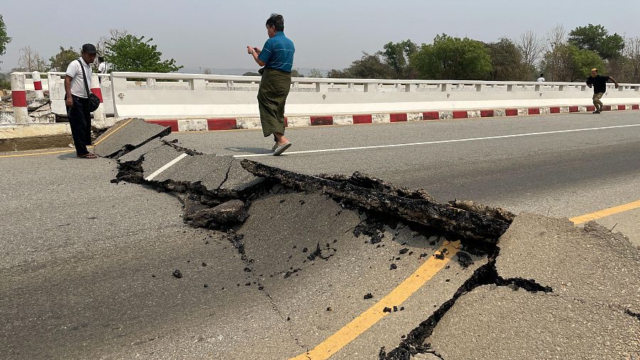 Varias personas observan un puente dañado en la autopista Naipyidó-Yangón