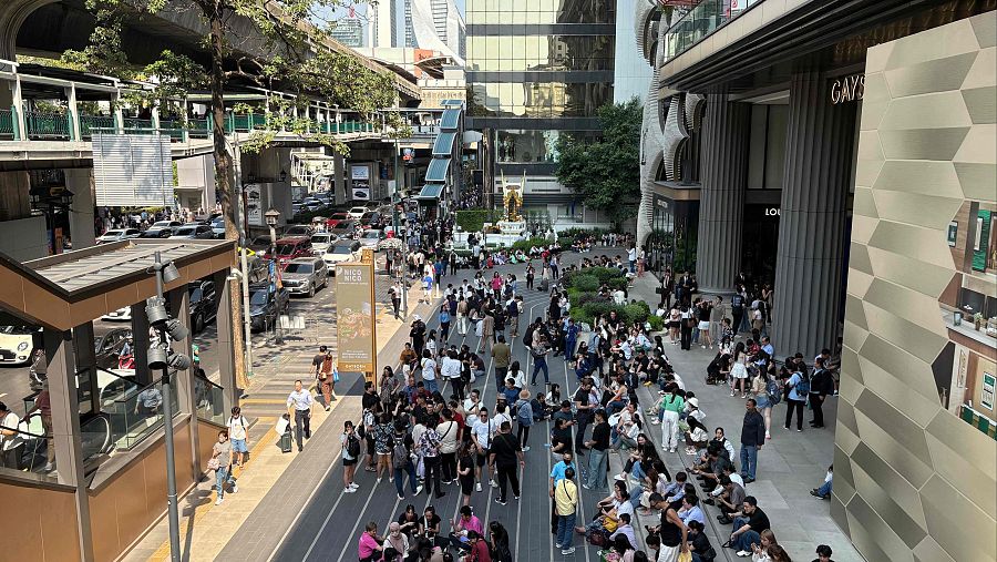 La gente se reúne fuera de un centro comercial en Bangkok después de un terremoto