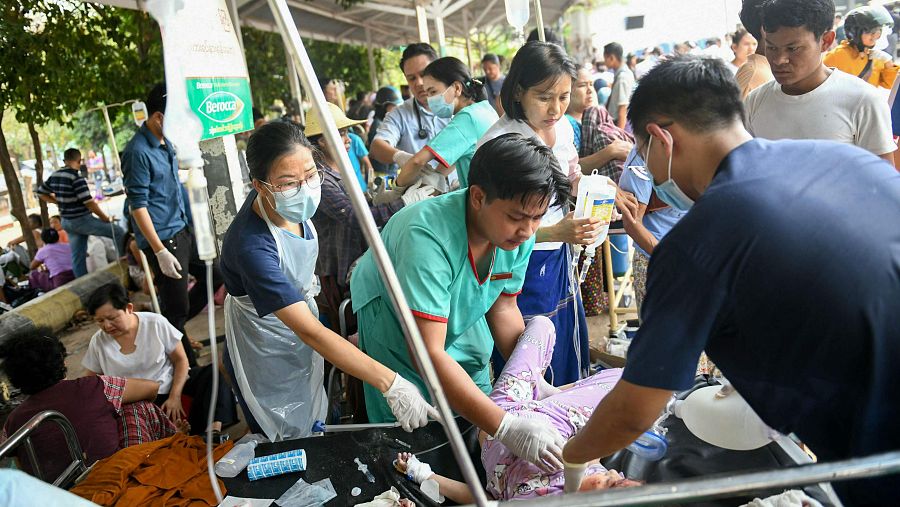 Trabajadores médicos atienden a un superviviente del terremoto en una cama del recinto de un hospital en Naipyidó
