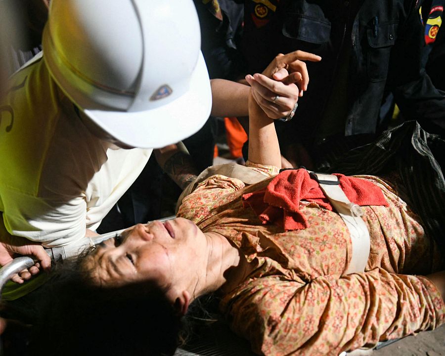 Ye Aung acompaña a su esposa Phyu Lay Khaing de camino al hospital tras ser rescatada de entre los escombros del edificio de apartamentos Sky Villa Condo, en Mandalay
