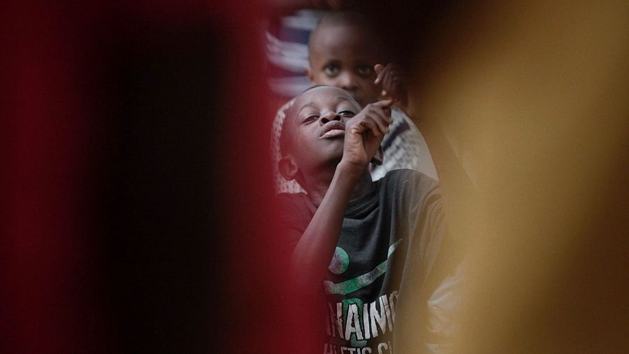 Dos niños, uno con camiseta que parece decir 