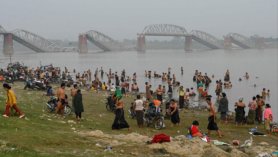 Varias personas se bañan en el río Irrawaddy frente al derruido puente de Ava en Sagaing, el 2 de abril de 2025
