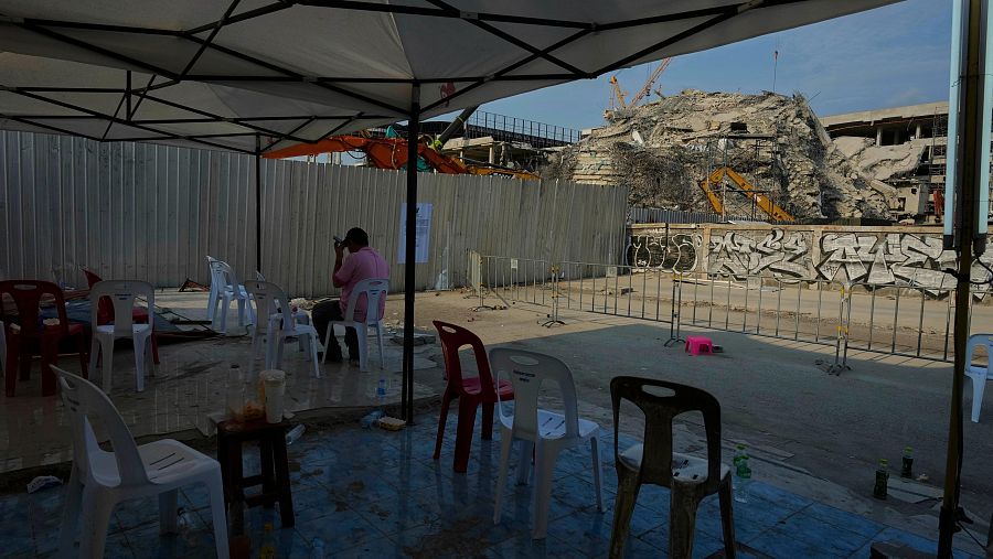 Una persona habla por su teléfono móvil en el solar de un rascacielos en construcción que se derrumbó tras un terremoto en Bangkok, Tailandia, el viernes 4 de abril de 2025.