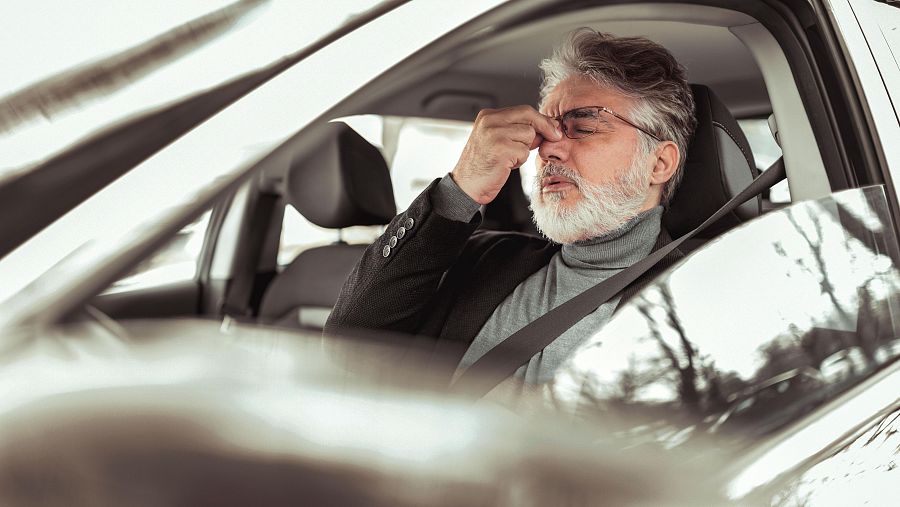 Un conductor muestra su cansancio en la conducción cerrando sus ojos y frotándose el entrecejo