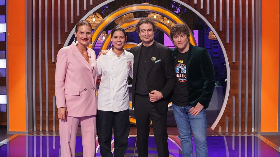 Samantha Vallejo-Nágera, una concursante, Pepe Rodríguez y Jordi Cruz en el plató de MasterChef.  Samantha apoya su mano en el hombro de la concursante.  Escenografía circular.
