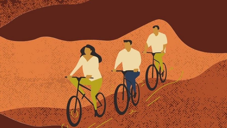 Tres personas en bicicleta sobre fondo abstracto naranja y marrón oscuro con líneas amarillas que sugieren movimiento. Ropa en tonos crema, verde oliva y azul oscuro.