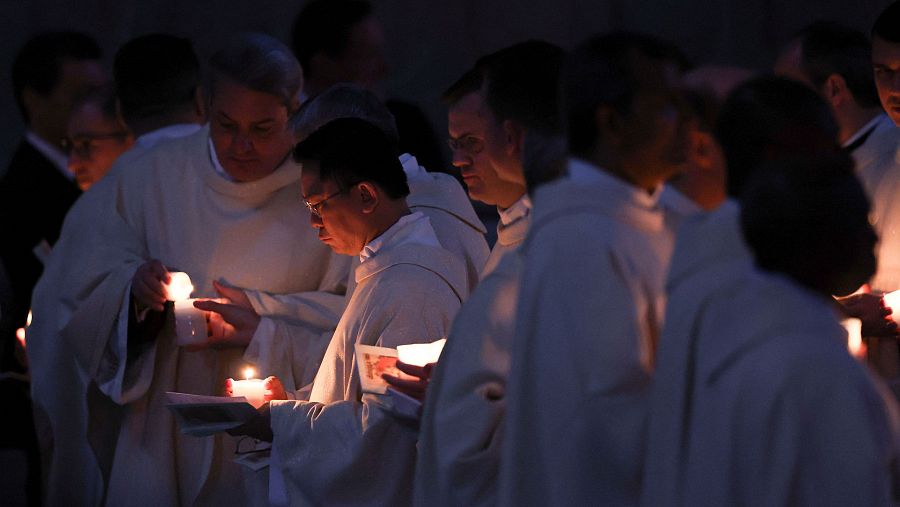 Miembros del clero sostienen velas en la Vigilia Pascual en la Basílica de San Pedro del Vaticano