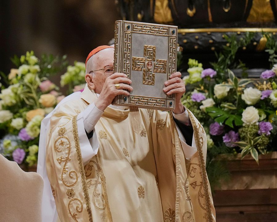 Giovanni Battista Re sostiene el Libro Sagrado mientras dirige la Vigilia Pascual en la Basílica de San Pedro del Vaticano