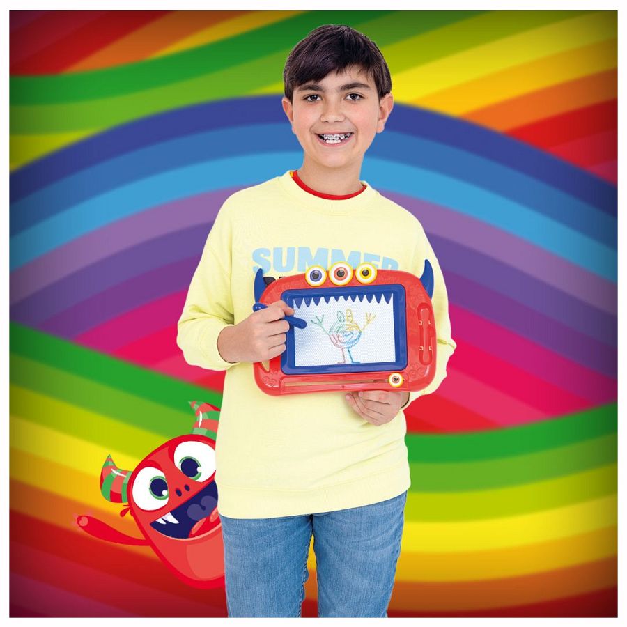 Niño con aparato sostiene pizarra roja con forma de monstruo y dibujo infantil; fondo arcoíris; mascota monstruo rojo en esquina.