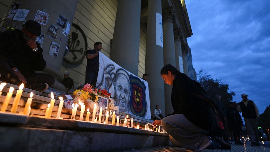 Una mujer enciende velas en el exterior de la Catedral Metropolitana de Buenos Aires, tras la muerte del Papa Francisco