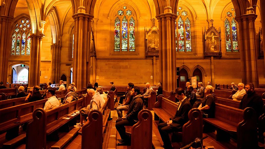 Varios fieles rezan durante un servicio de luto por la muerte del papa Francisco, en la Catedral de Santa María, en Sídney