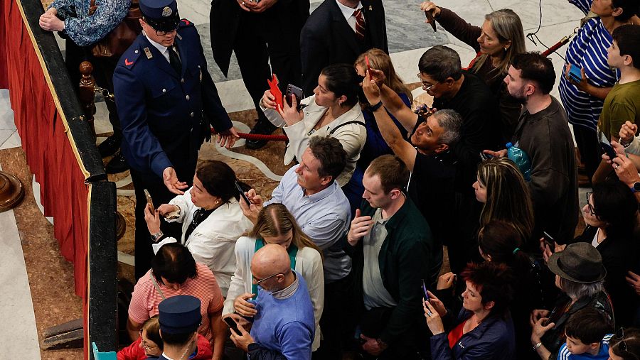 Los fieles toman fotografías del difunto papa Francisco.