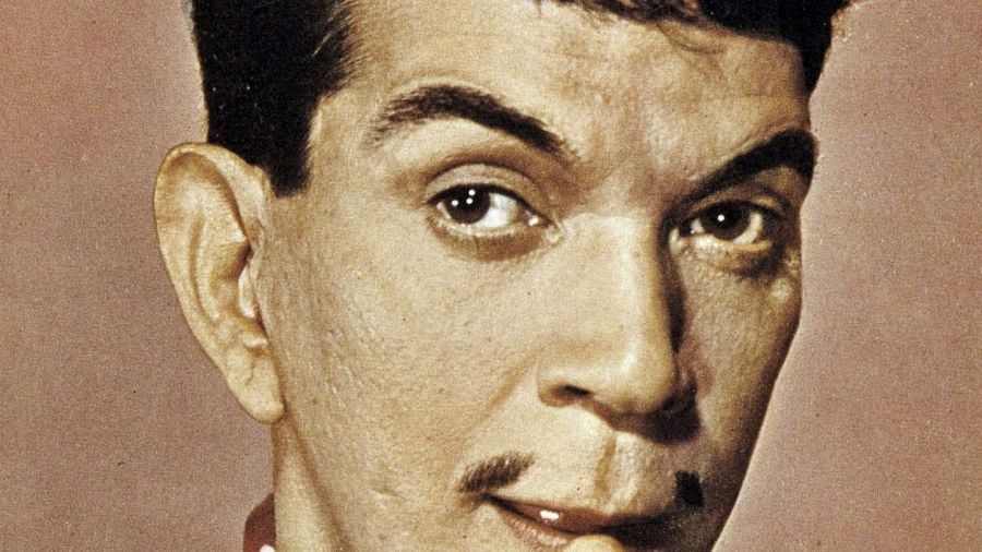 Retrato en primer plano de Cantinflas con expresión pícara y bigote, en una foto sepia de estilo vintage.